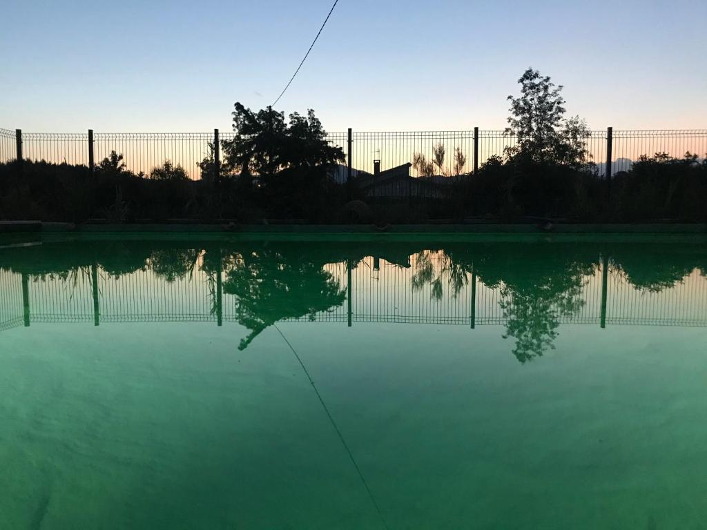 un reflet d'une clôture dans un bassin d'eau dans l'établissement Les Balusets, à Vinezac