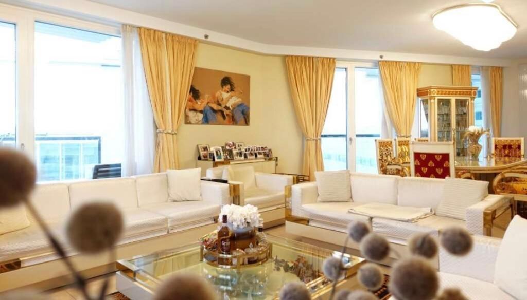 a living room with white furniture and large windows at Luxury Diplomat-Penthouse - UNO City Vienna in Vienna
