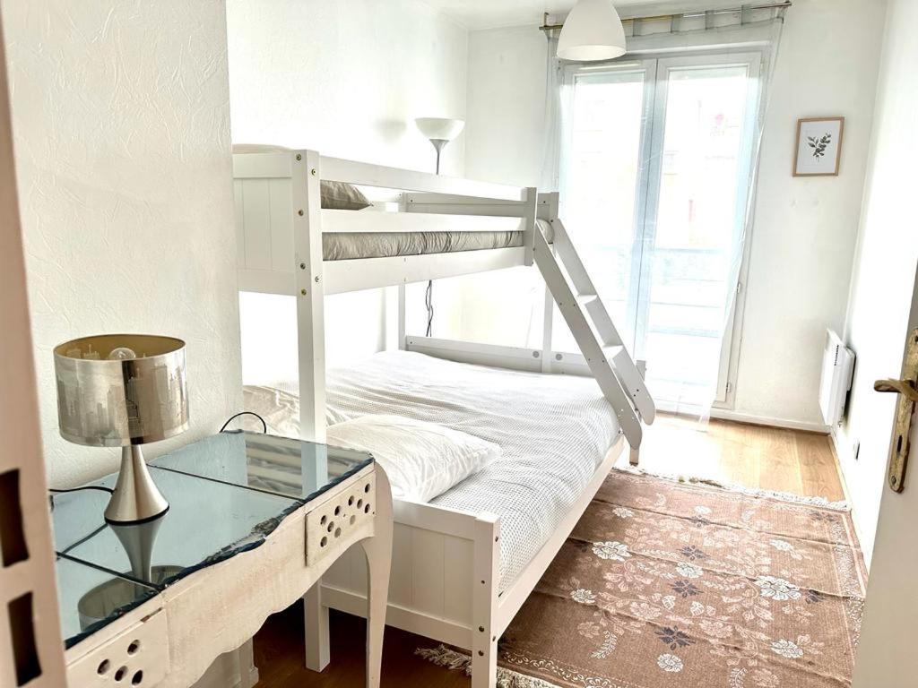 een slaapkamer met een stapelbed en een glazen tafel bij BIG logement , JO2024, stade de France, PARIS, métro , parking gratuit in Saint-Denis