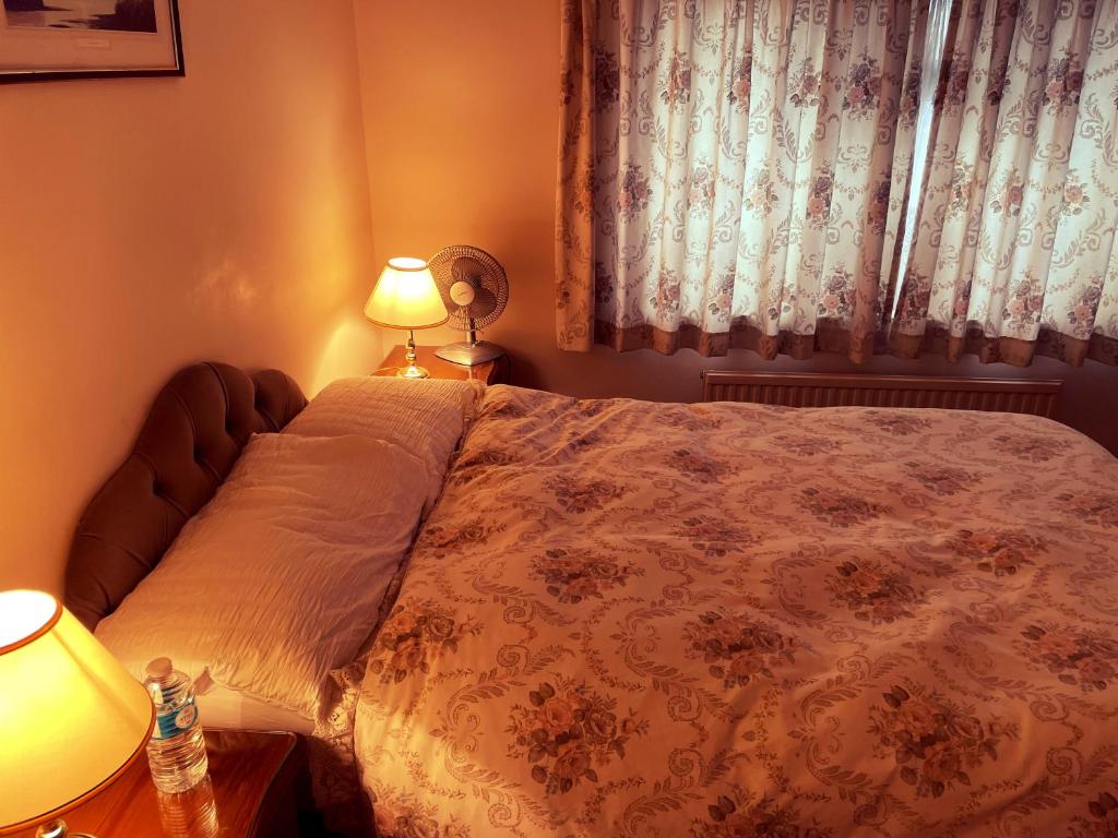 1 dormitorio con 1 cama, 2 lámparas y ventana en God’s Abode, en Windsor
