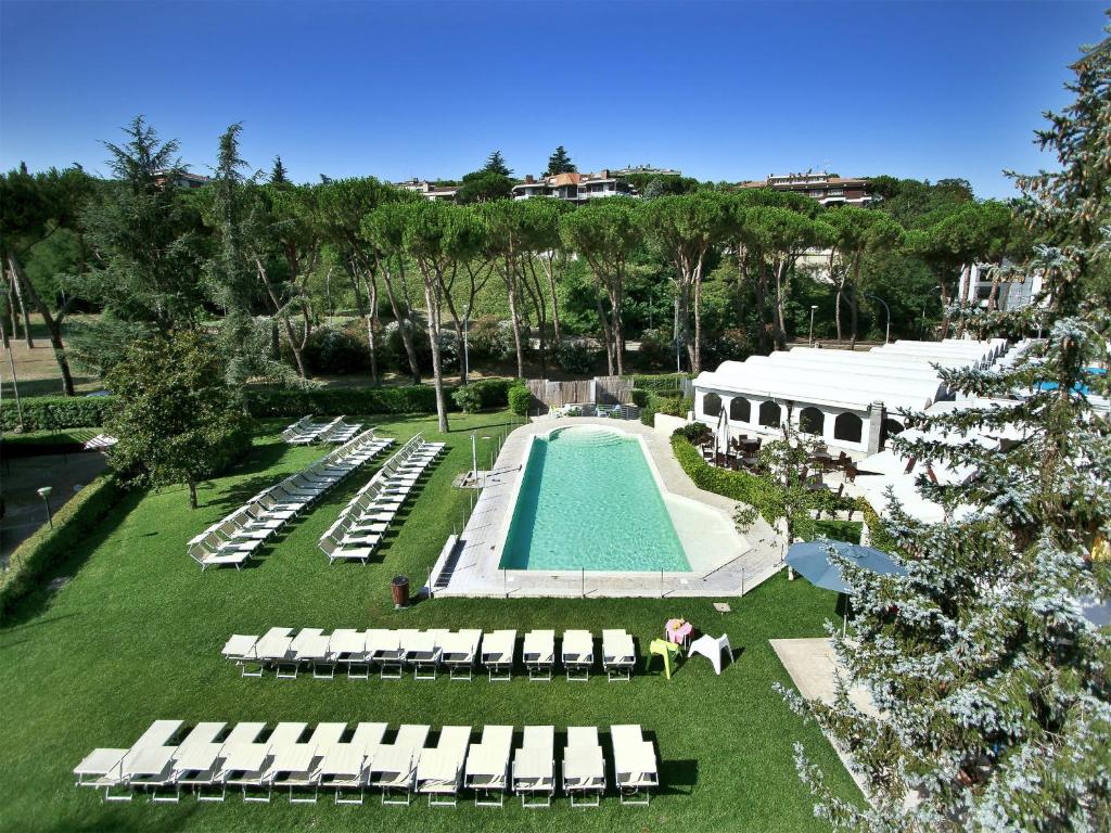 vista aerea su una piscina con sedie a sdraio e su un resort di All Time Relais & Sport Hotel a Roma