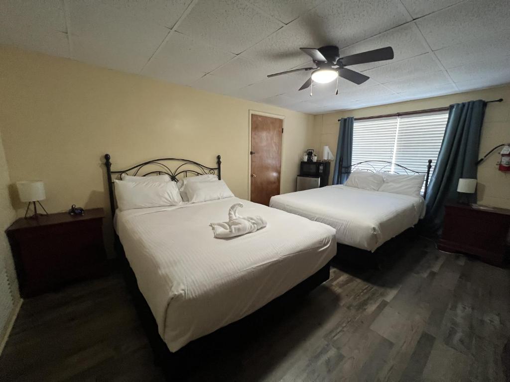 um quarto com 2 camas e uma ventoinha de tecto em JI7, A Queen Guest Room at the Joplin Inn at entrance to the resort Hotel Room em Mount Ida