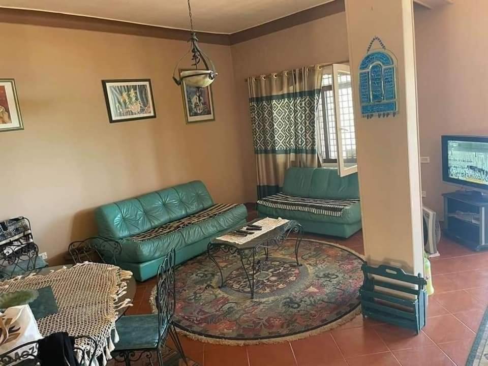 een woonkamer met een bank en een tafel bij فيلا العمر in Alexandrië