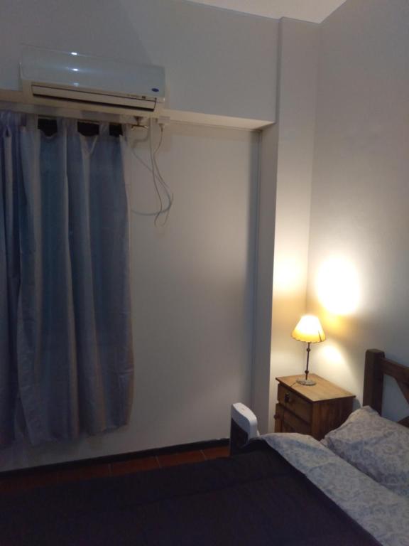 1 dormitorio con cama, lámpara y ventana en Departamento céntrico en Mendoza