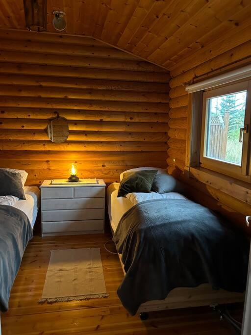 una camera con 2 letti su una parete in legno di Luxury cottage located in the Golden Circle, mountain view! a Laugarvatn