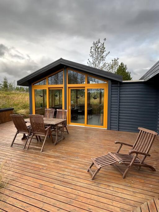 una terrazza con sedie e tavolo e una casa di Luxury cottage located in the Golden Circle, mountain view! a Laugarvatn