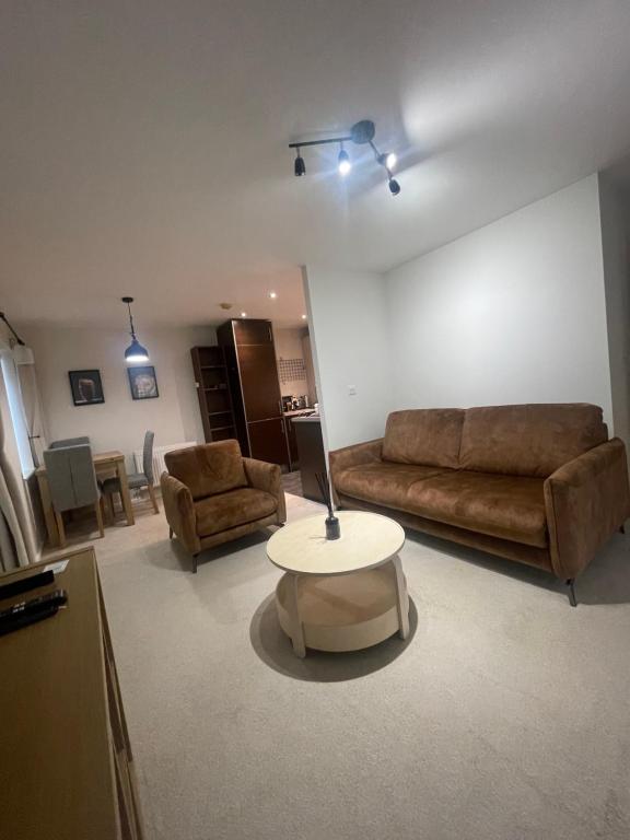 a living room with a couch and a table at The Retreat at Harlow in Potter Street