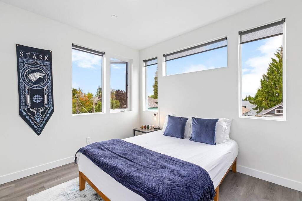 a white bedroom with a bed and two windows at The Sweet Suite in the North in Seattle