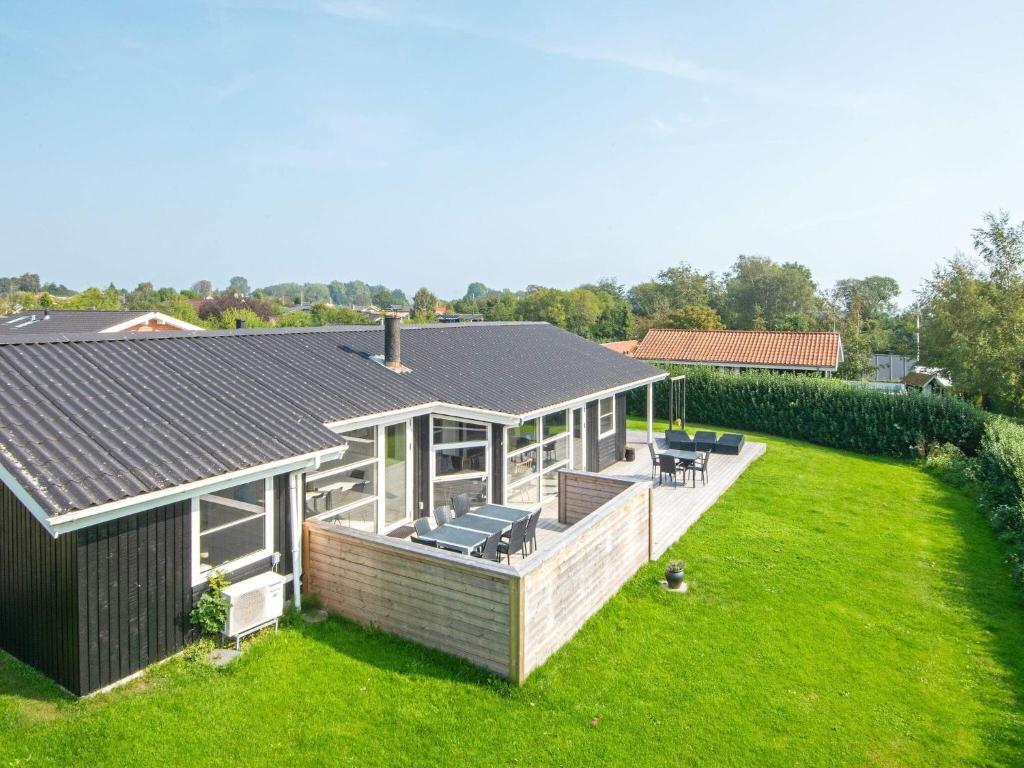 a house with a large deck with chairs on it at 10 person holiday home in Juelsminde in Sønderby