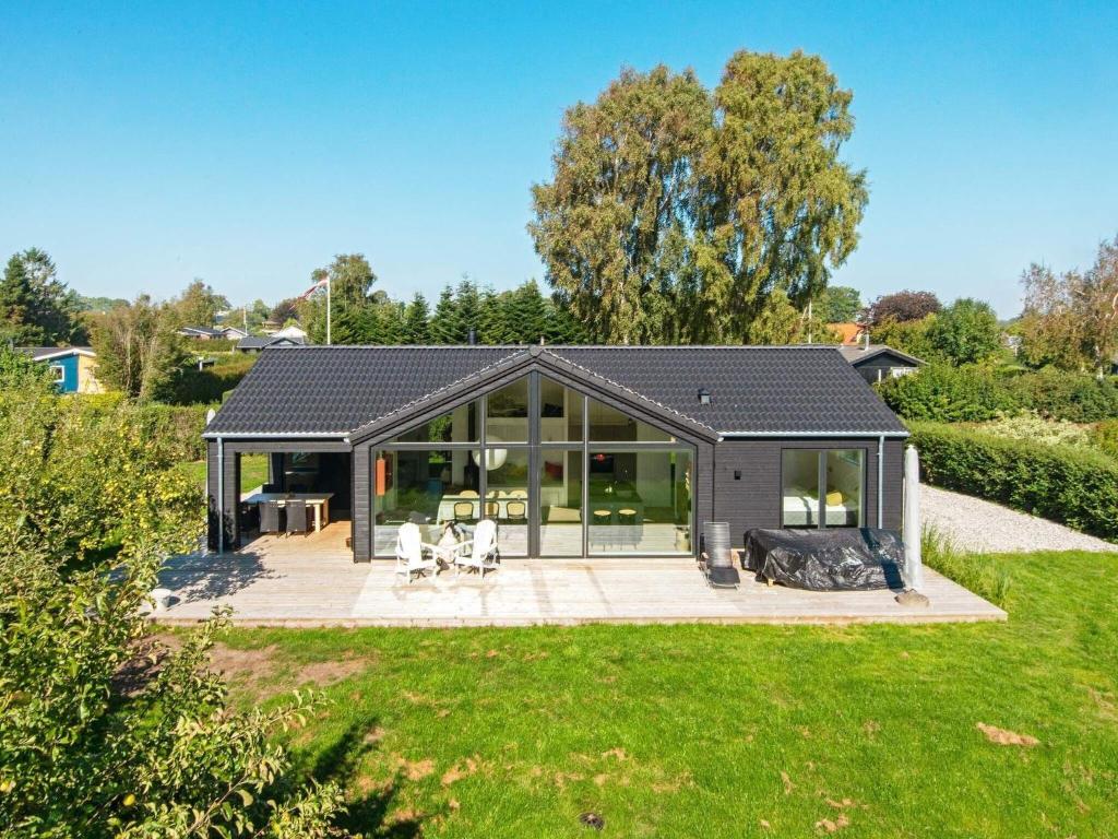 a home with a conservatory and a house with a yard at Family Holiday Home in Juelsminde in Juelsminde