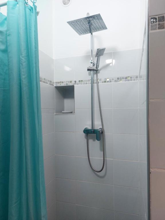 a shower in a bathroom with a blue shower curtain at Perle proche gare maritime et croisières in Pointe-à-Pitre