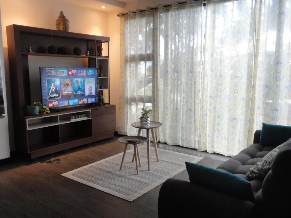 uma sala de estar com um sofá e uma televisão em Hermoso Shanti House en Vista Hermosa 2 em Guatemala