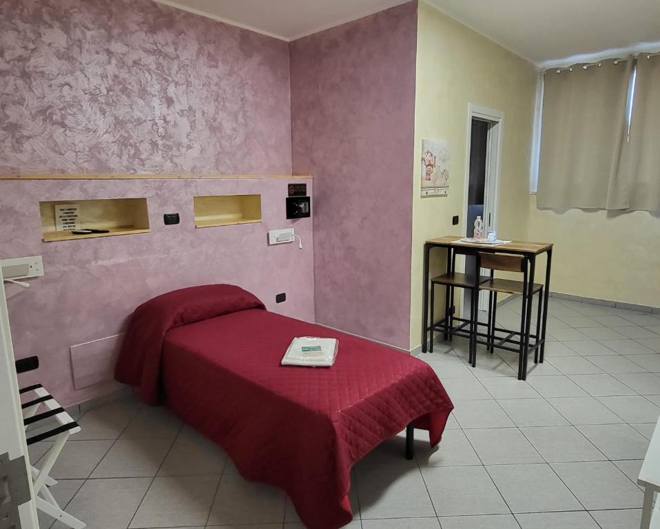 sypialnia z łóżkiem z czerwonym kocem i stołem w obiekcie HomeFamily w mieście Lido di Ostia