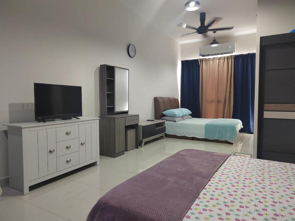 a bedroom with a bed and a flat screen tv at STUDIO SUITE HOMESTAY KLIA in Sepang