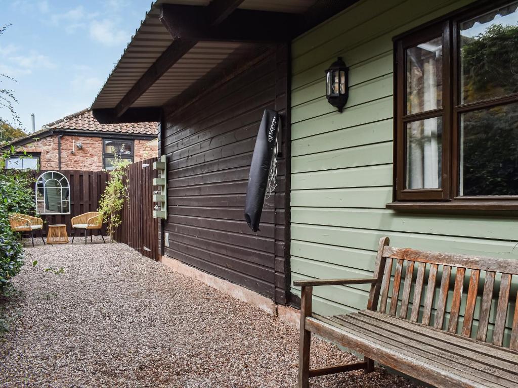 a wooden bench sitting outside of a house at Daisys Dairy in Bishops Lydeard