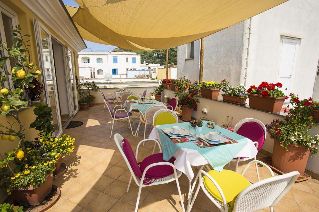 eine Terrasse mit Tischen und Stühlen auf dem Balkon in der Unterkunft B&B Celestina Ischia in Ischia
