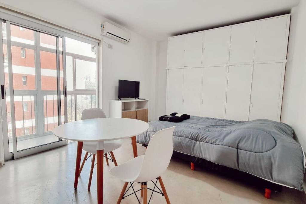a bedroom with a bed and a table and chairs at Studio en Las Cañitas in Buenos Aires