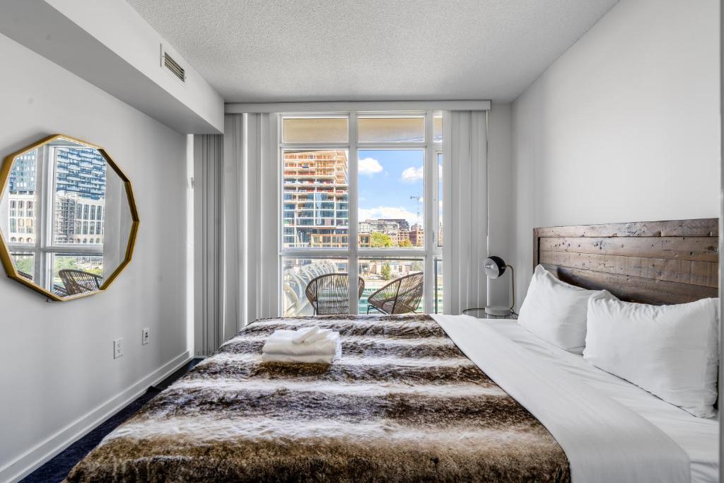 a bedroom with a large bed with a large window at Family oriented Downtown Toronto 2BDRM Condo with Parking & office space in Toronto