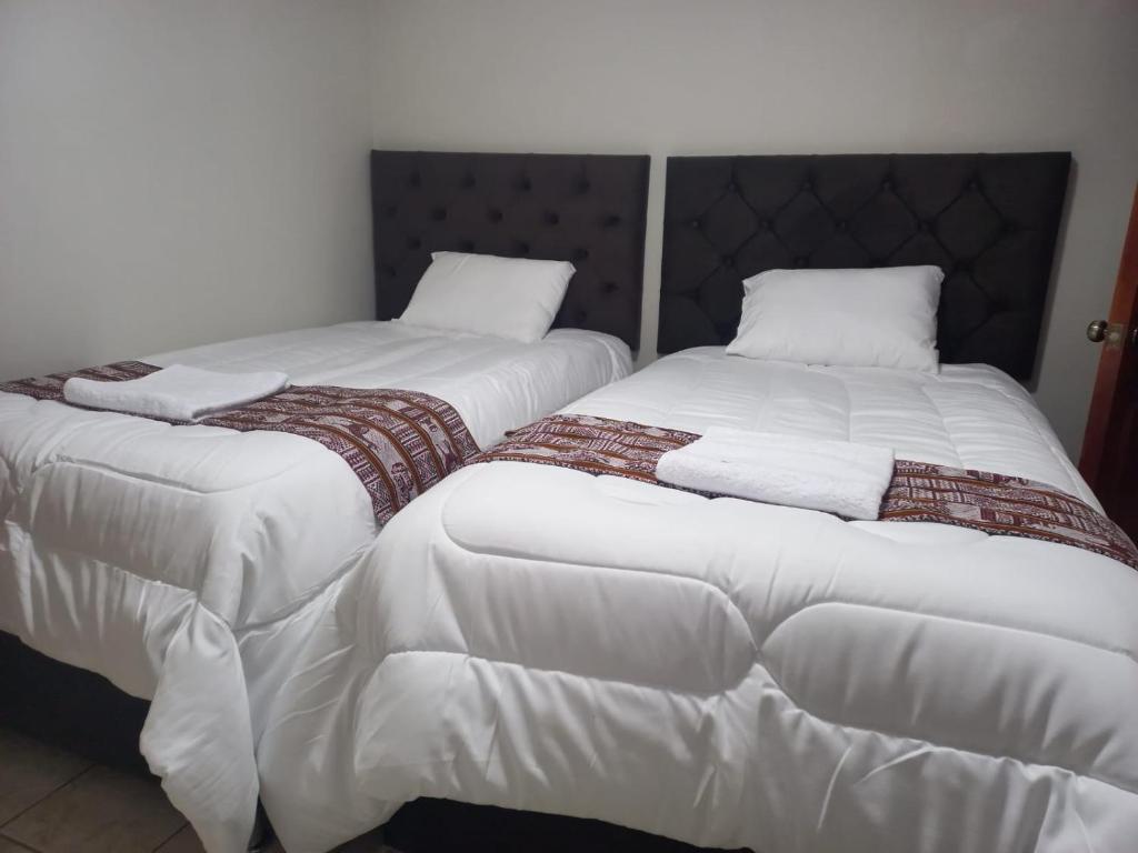 twee bedden naast elkaar in een kamer bij Ataraxia Light House in Cuzco