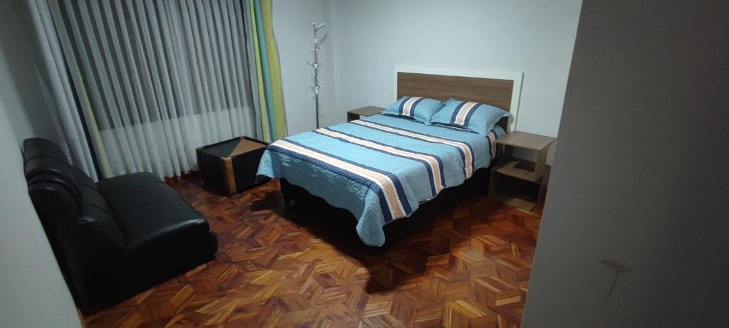 ein Schlafzimmer mit einem Bett und einem Stuhl darin in der Unterkunft GOLDEN DREAMS in Callampaya