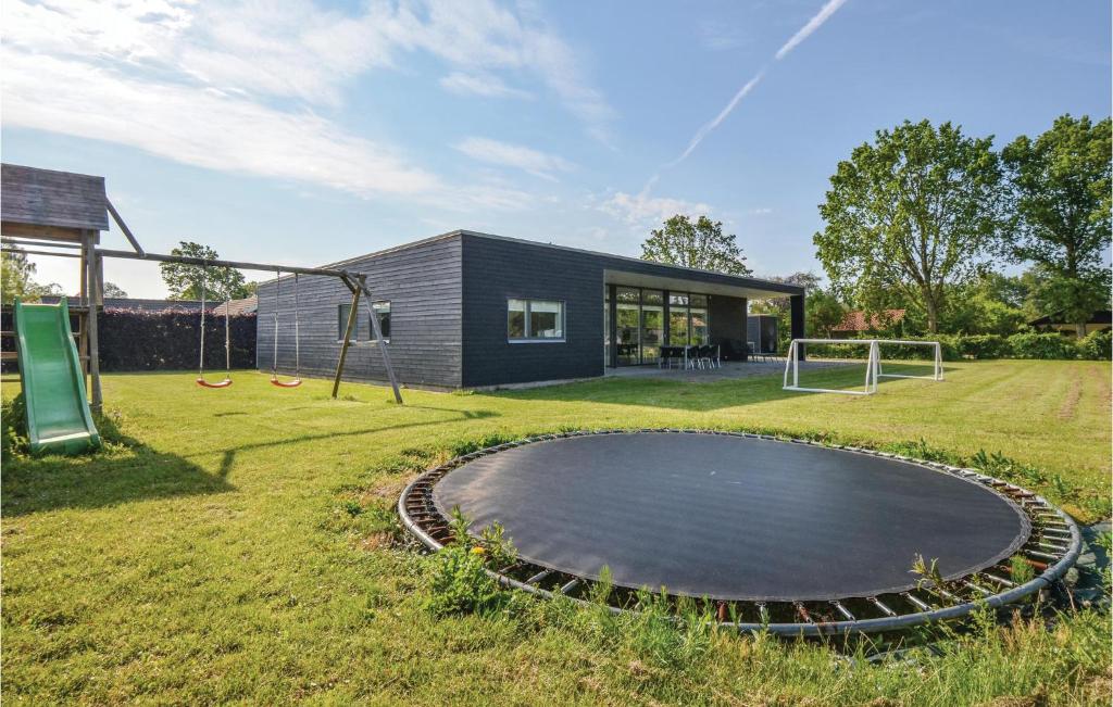a house with a trampoline in a yard at Lovely Home In Ebeltoft With Wifi in Ebeltoft