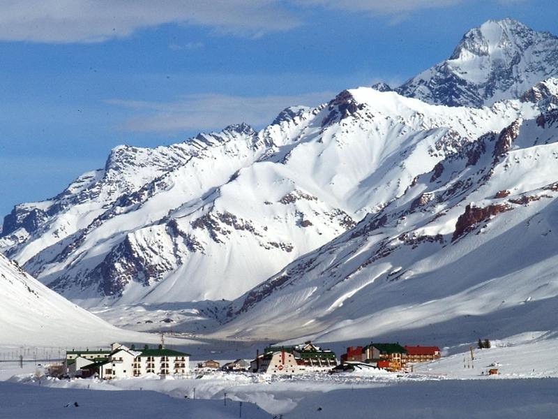 einen schneebedeckten Berg mit einer Stadt davor in der Unterkunft Aires de Montaña - Departamento en Los Penitentes, Mendoza in Los Penitentes