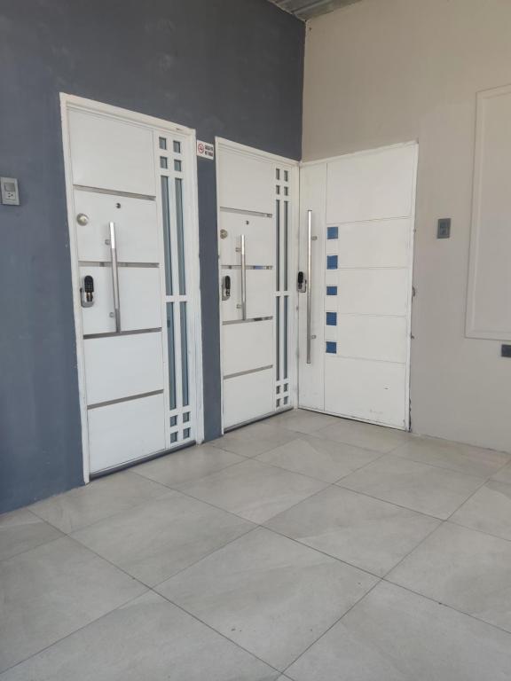 um quarto com três portas de garagem e um piso de azulejo em HABITACIÓN JUNIOR EN CDLA PRIVADA em Guayaquil