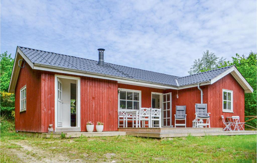 una casa roja con una terraza y sillas. en Cozy Home In Ebeltoft With Wifi, en Ebeltoft
