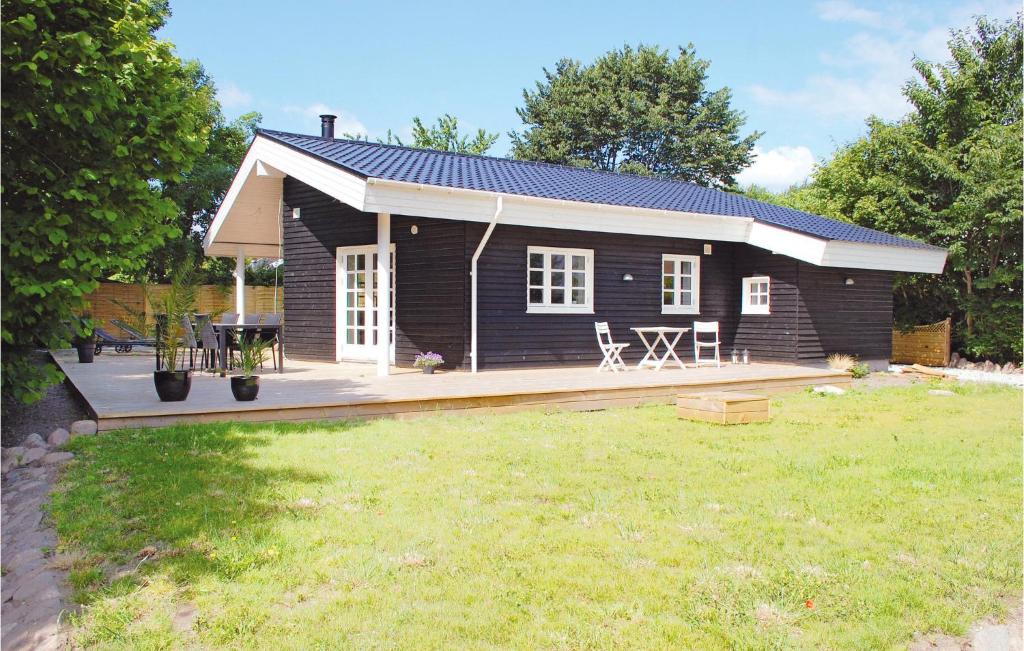 ein kleines Blockhaus mit einer Terrasse im Hof in der Unterkunft Lovely Home In Hornslet With Kitchen in Hornslet