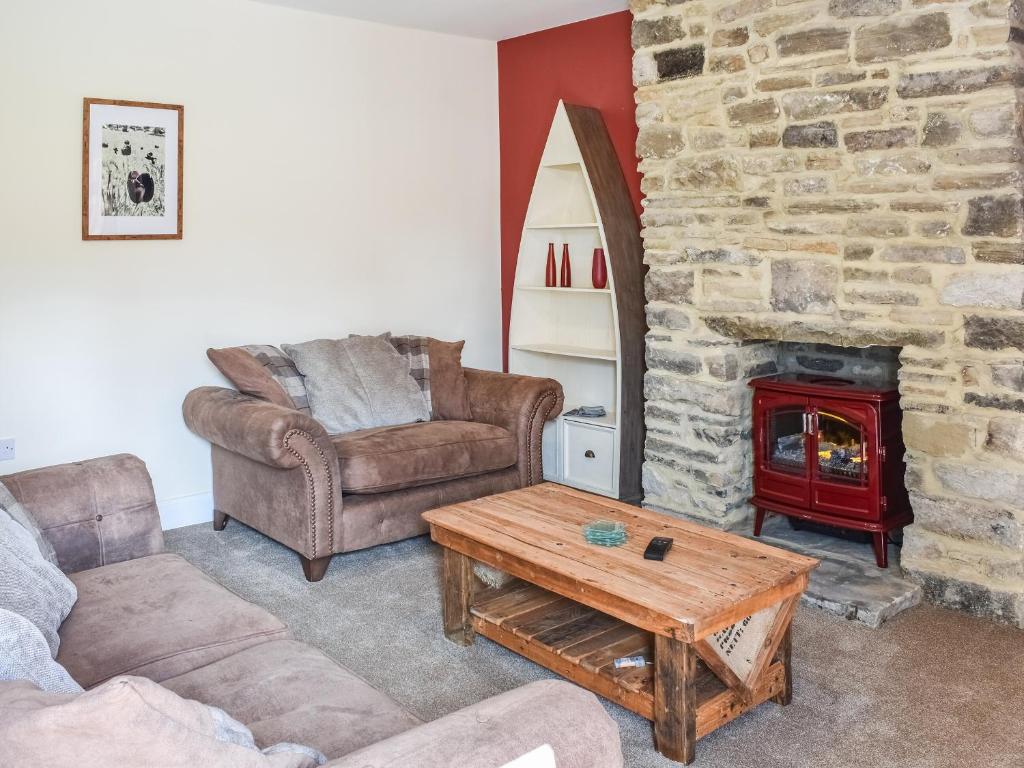 sala de estar con sofá y chimenea en Woodside Cottage, en Low Etherley