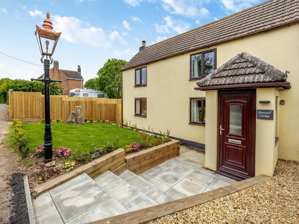 a house with a red door and a yard at Huntspill Cottage in Holbeach