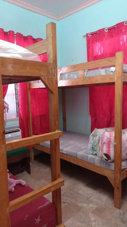 Ce dortoir comprend 2 lits superposés et des rideaux rouges. dans l'établissement JVC Home (Beside Federico's Resto), à Ormoc