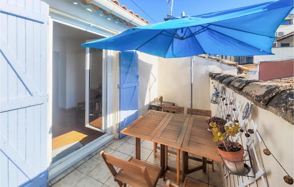 um guarda-chuva azul sobre uma mesa de madeira na varanda em Beautiful Home In Abeilhan With Wifi em Abeilhan