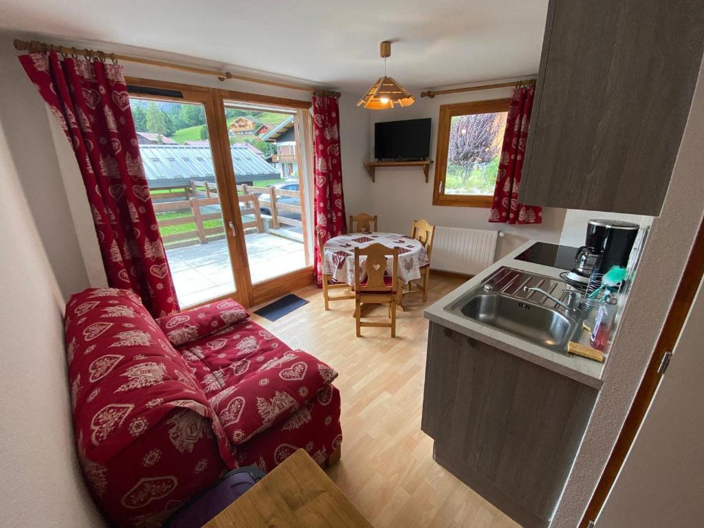 eine Küche und ein Wohnzimmer mit einem Sofa und einem Tisch in der Unterkunft Charmant 2 pièces avec terrasse et parking proche des pistes à La Chapelle-d'Abondance - FR-1-692-89 in La Chapelle-dʼAbondance