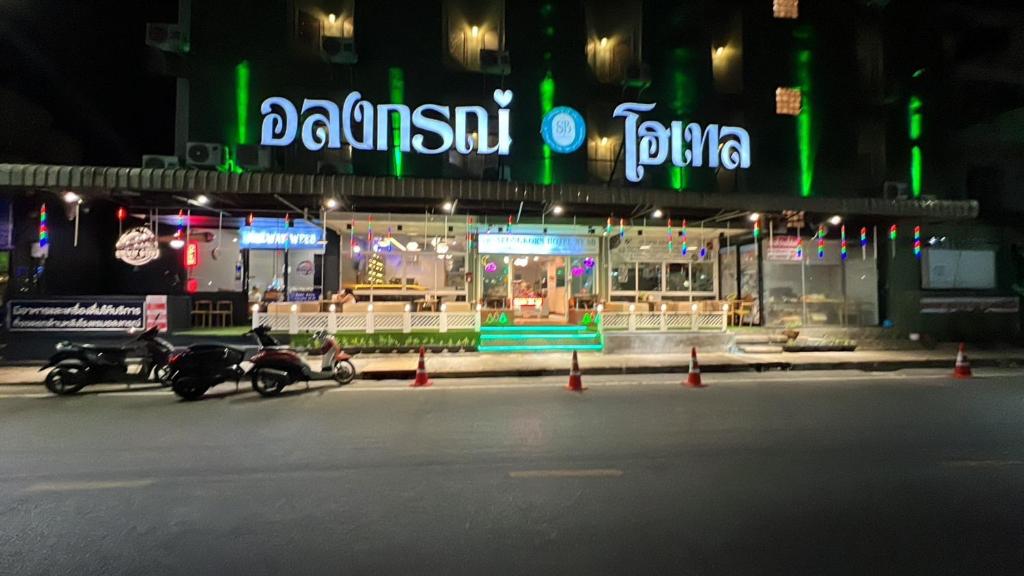 ein Restaurant mit Motorrädern, die nachts davor geparkt sind in der Unterkunft Alongkorn hotel by SB in Samut Songkhram