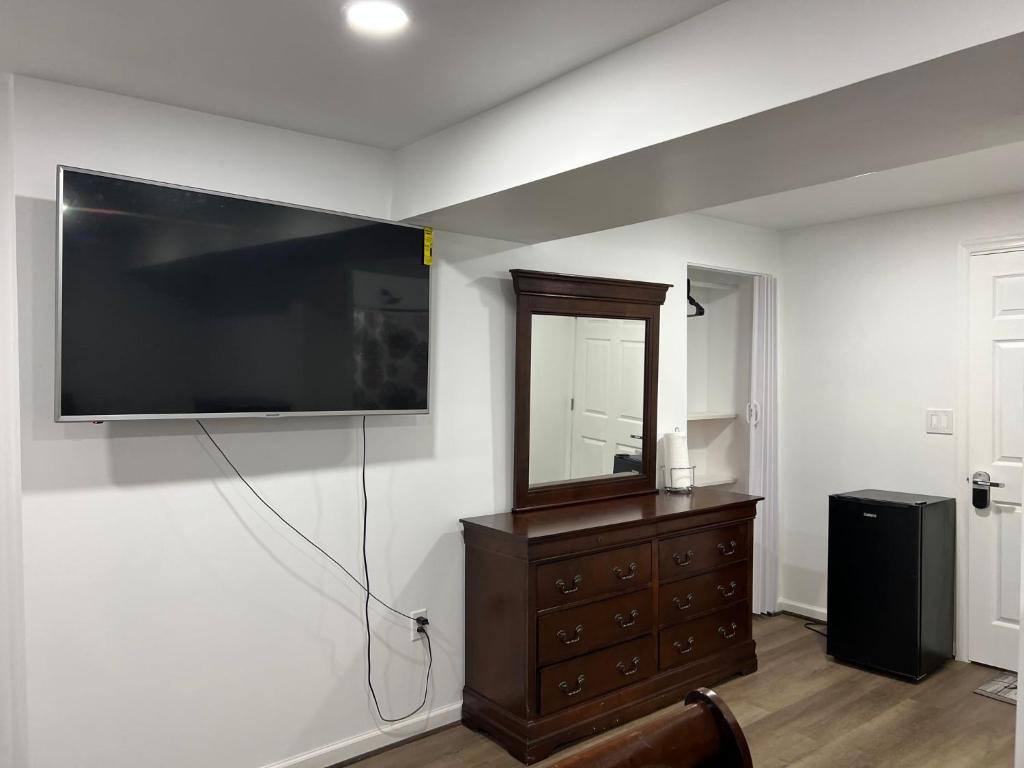 uma sala de estar com uma grande televisão de ecrã plano na parede em Executive Guesthouse em Middletown