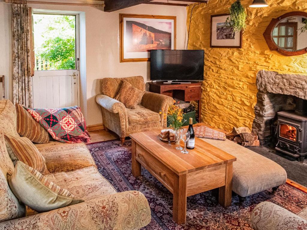 ein Wohnzimmer mit einem Sofa und einem Kamin in der Unterkunft Hen Efail - Old Smithy in Tregaron