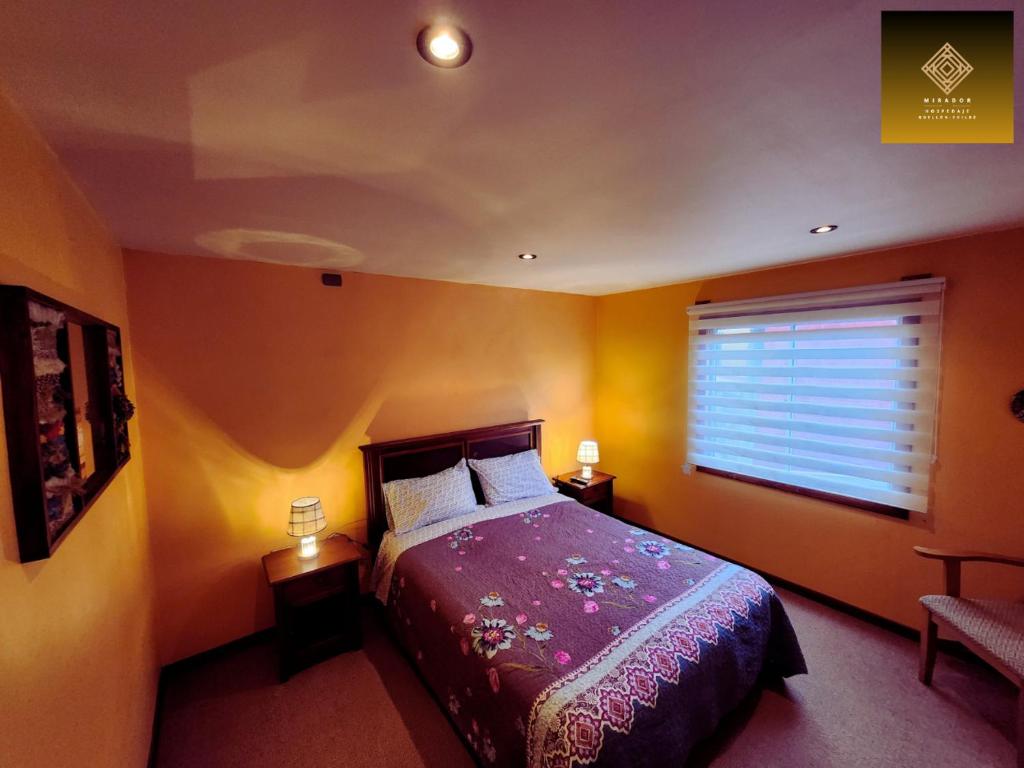 Un dormitorio con una cama grande y una ventana en Hospedaje Mirador Quellón en Quellón
