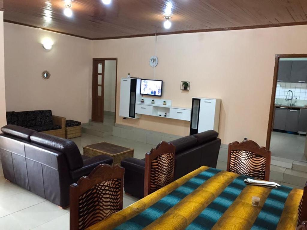 a living room with a couch and chairs and a tv at Villa Sophie à Sassara Pk 12 Bangui in Bangui