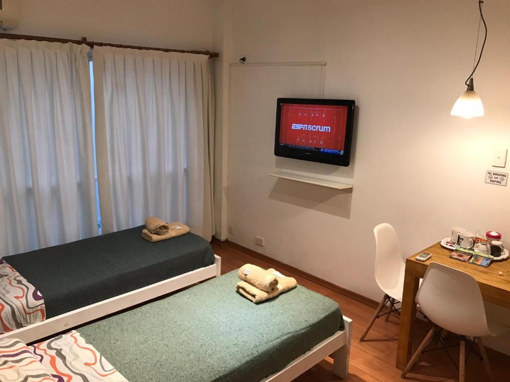 a bedroom with a bed and a desk and a tv at Dodis Studio Recoleta . to 6 Blocks from Cemetery in Buenos Aires