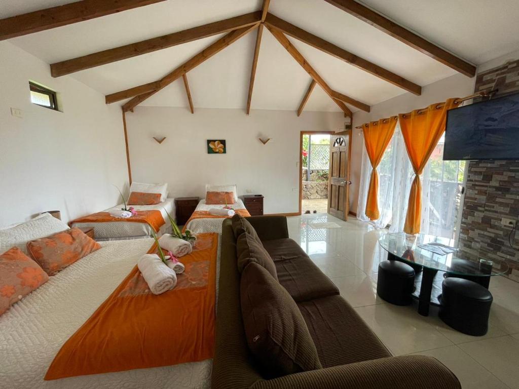 sala de estar con 2 camas y sofá en Mata ki te Rangi Rapa Nui, en Hanga Roa