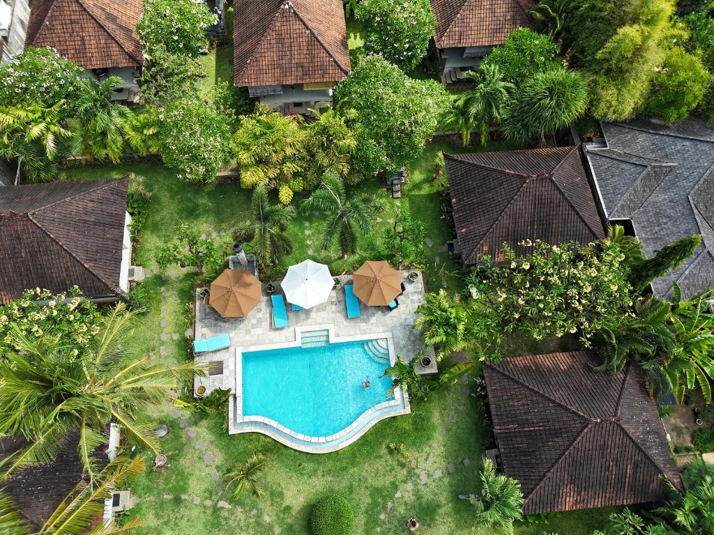 una vista aérea de un complejo con piscina y sombrillas en Di Abian Resort, en Amed