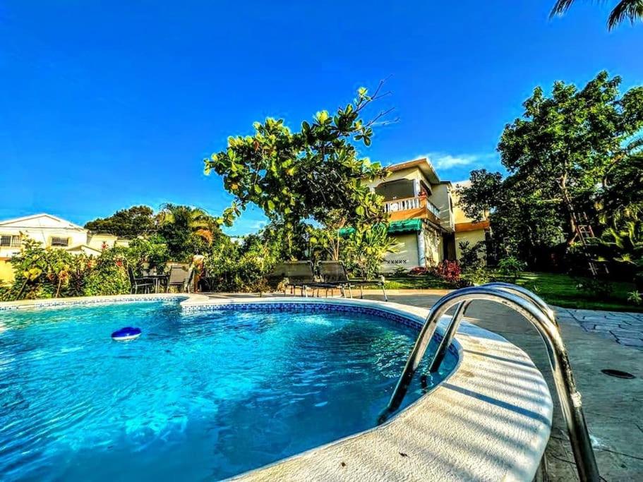 a swimming pool with a bench next to a house at Villa Hermosa1 / Piscina in San Felipe de Puerto Plata