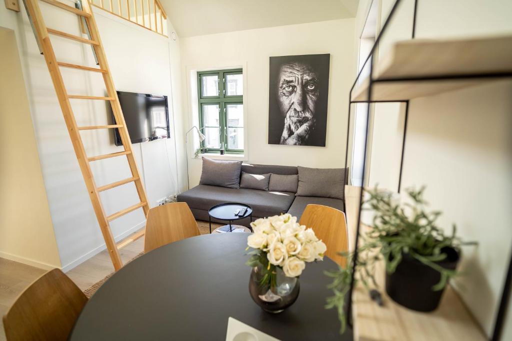 uma sala de estar com uma mesa e um sofá em Vibrant apartment on bustling street, above a restaurant Perfect for tourists, em Stavanger