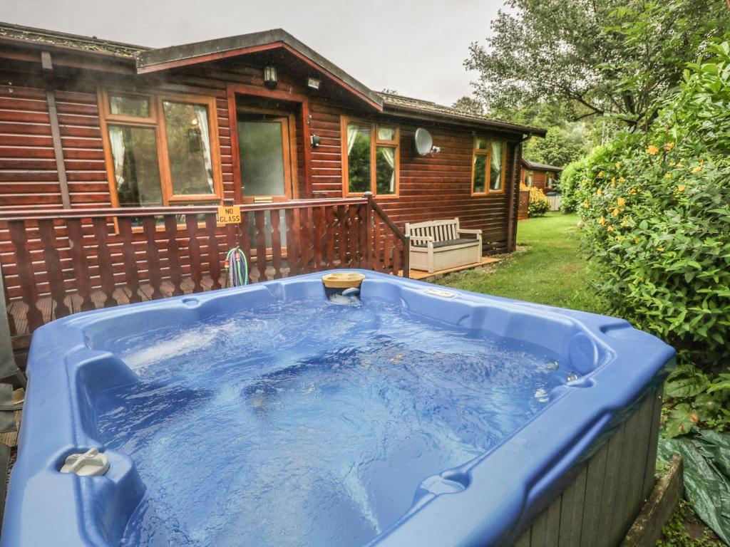 a hot tub in front of a log cabin at Langdale Lodge 15 in Windermere