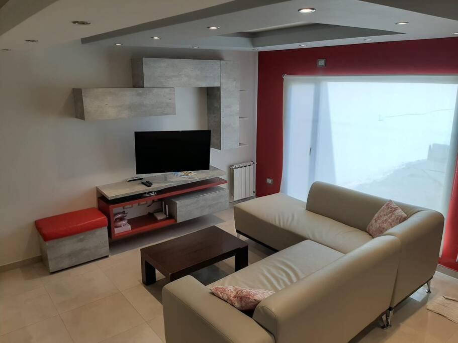 ein Wohnzimmer mit einem Sofa und einem Flachbild-TV in der Unterkunft Moderno Duplex - Alquiler en Comodoro Rivadavia in Comodoro Rivadavia