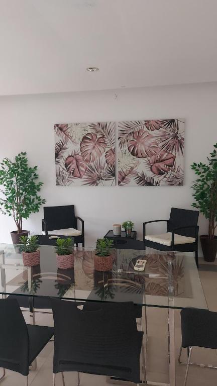a room with a glass table with chairs and potted plants at Minimalist Condo Studio City Tower 2 Filinvest Alabang Muntinlupa in Manila