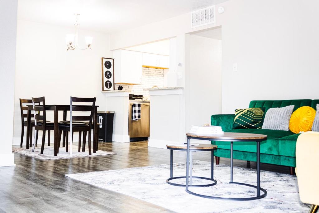 ein Wohnzimmer mit einem grünen Sofa und einem Tisch in der Unterkunft Walk to AT&T Stadium , Globelife from Cozy 2bd/ba Apartment in Arlington