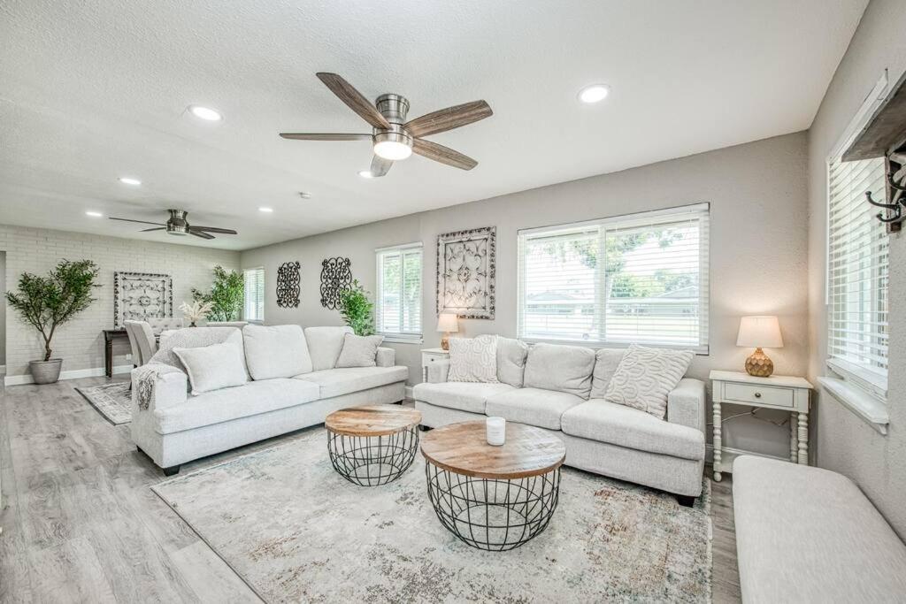a living room with white furniture and a ceiling fan at Fun City Haven Spacious Retreat in Fresno in Fresno