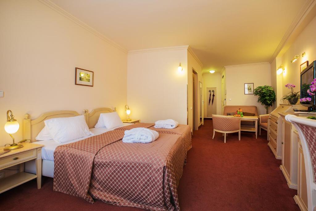 a hotel room with two beds with towels on them at Interhotel Central in Karlovy Vary